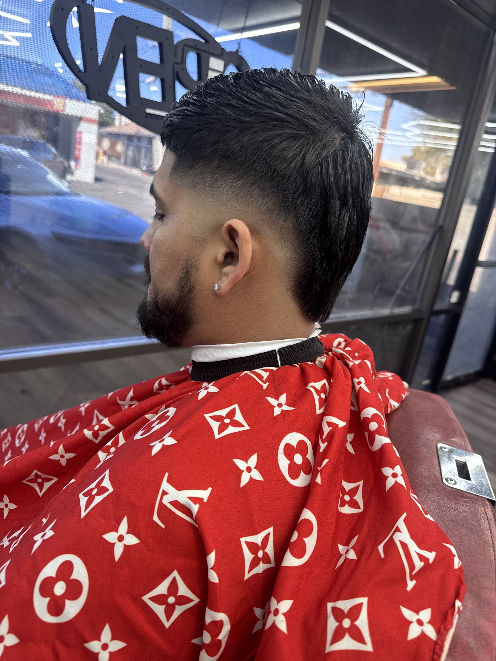 Back-side view of a men's textured haircut with a taper fade and beard